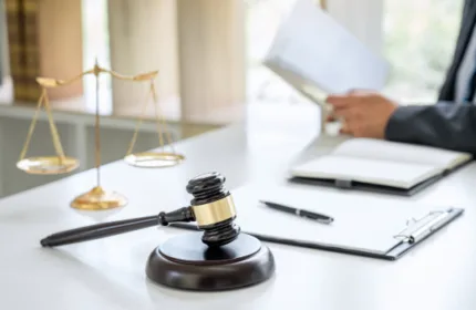 Legal gavel on a desk as someone reviews paperwork