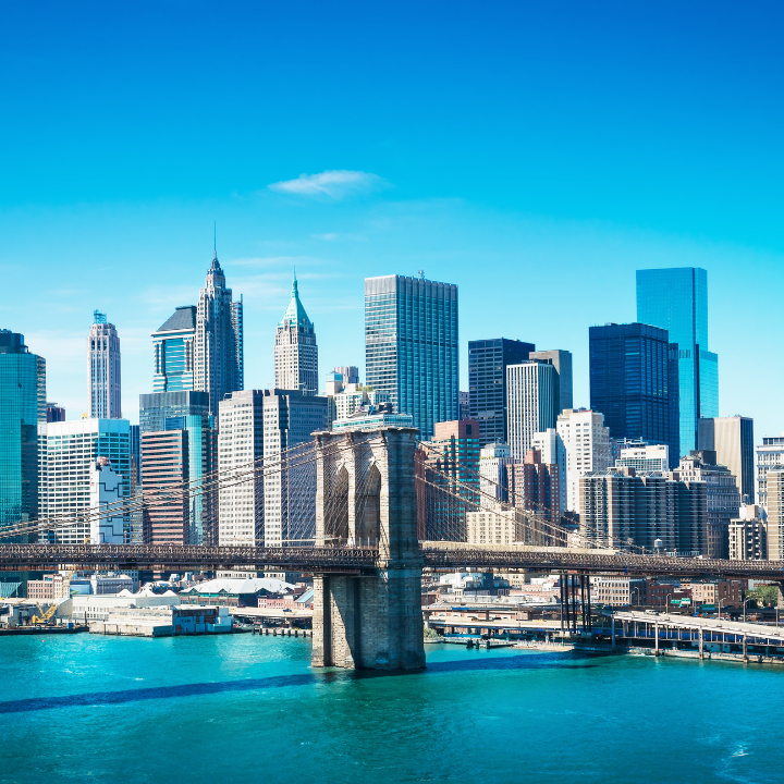 Daytime view of the Brooklyn Bridge stretching over the East River with the Manhattan skyline in the background, representing New York City’s business hub and the home of top temp NYC staffing and consulting experts, here for all your temp nyc needs.
