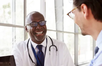 Nurse and patient in a clinical hallway, symbolizing IT systems supporting healthcare operations.