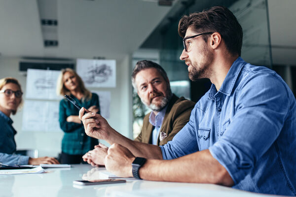 A group of professionals in a meeting discussing ideas around workforce challenges.