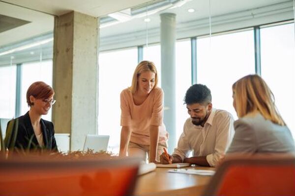 Team of professionals gathered around a conference table collaborating during an in-person meeting