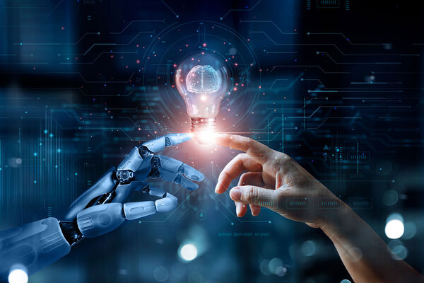 Two hands, one robotic and one human, reaching toward each other against a digital background, representing artificial intelligence and human collaboration.
